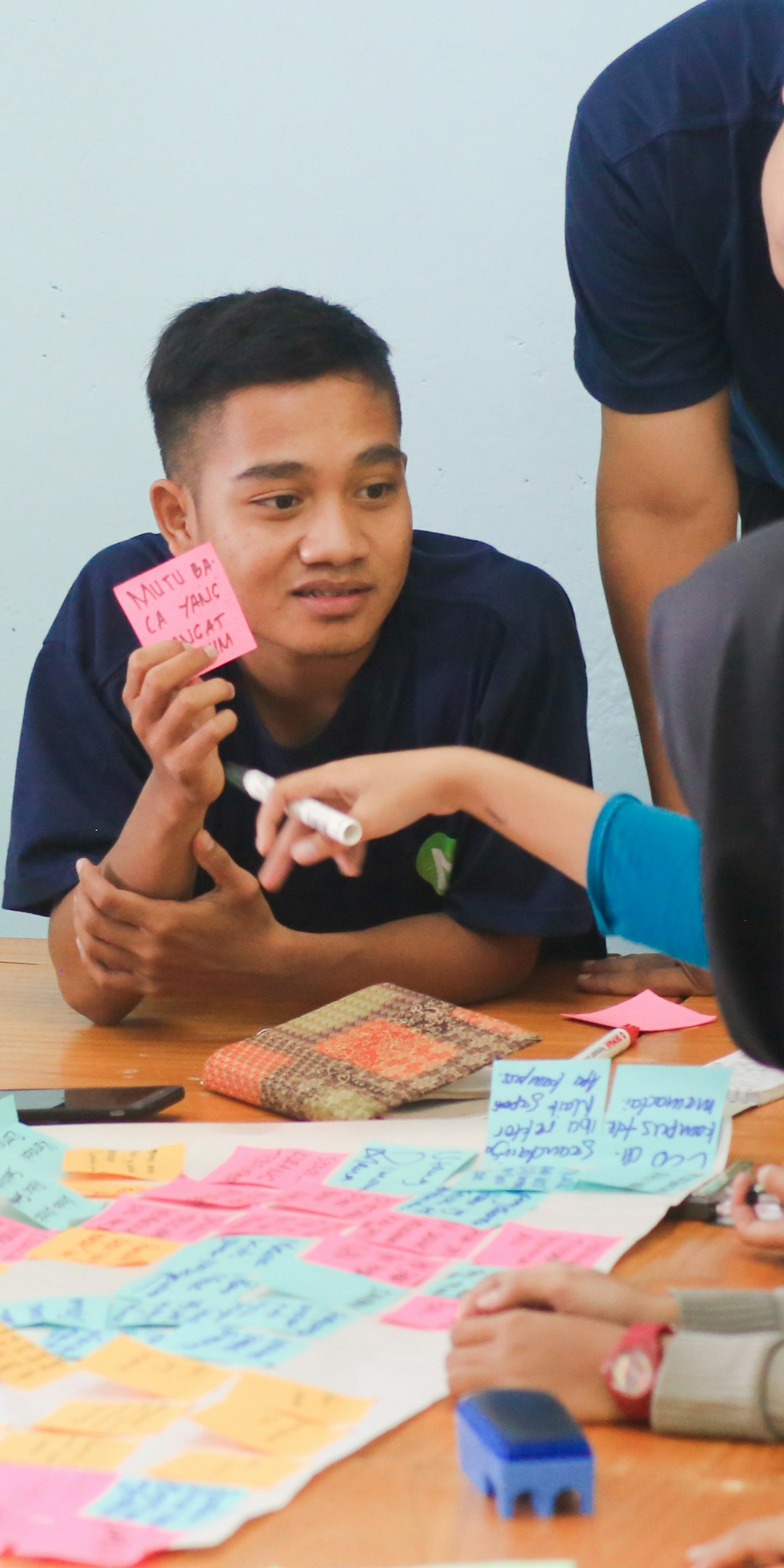 Trainer guiding participants in a group workshop with sticky notes